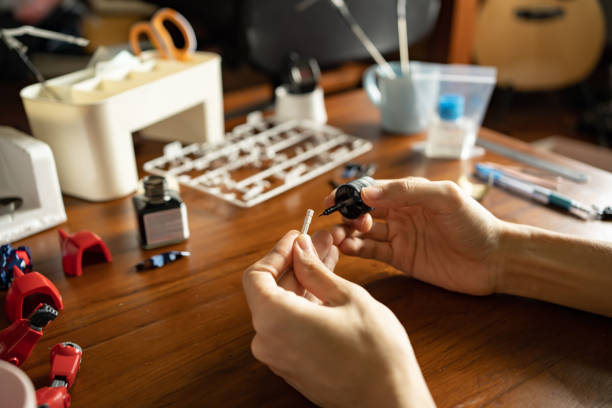 A man painting enamel paint on a plastic model kit A man painting enamel paint on a plastic model kit action figure stock pictures, royalty-free photos & images