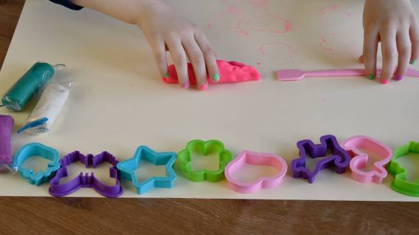 istock Toddler hands playing colorful play dough with plastic molds and plastic knife 1321251809