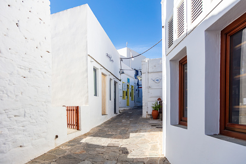 Greece, Sifnos island. May 19, 2021. Traditional greek architecture whitewashed buildings and narrow cobblestone streets at Apollonia village, sunny day, clear blue sky