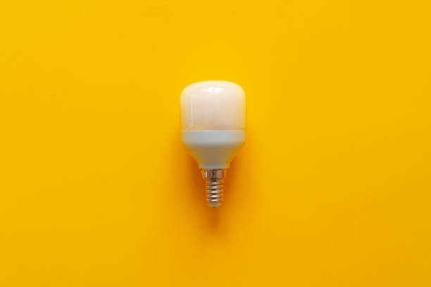 istock Light bulb on yellow paper background top view 1321253213