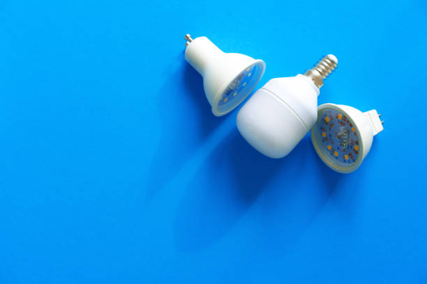 istock Light bulbs on blue paper background close up 1321254832