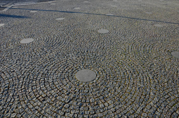 stone paving in the square folded into circles with a larger tile in the middle of gray granite pavement