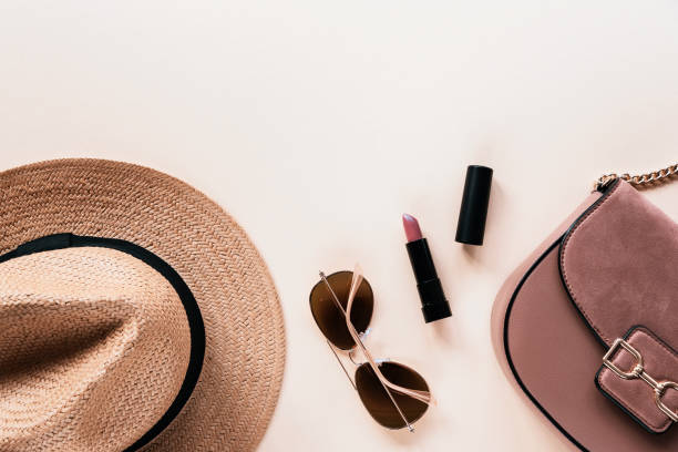 istock Flat lay with women's summer accessories on neutral background. Sunglasses, straw hat, lipstick and handbag. Top view, copy space 1321255366