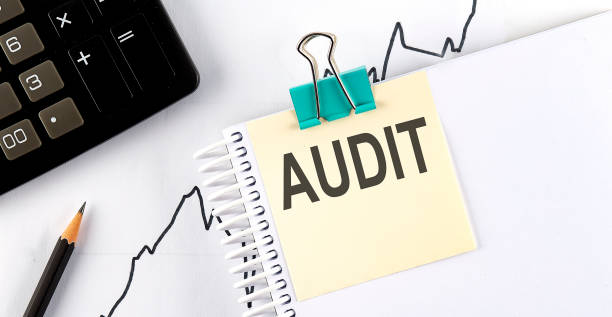 istock AUDIT text, written on a sticker with calculator,pencil on chart background. 1321255921