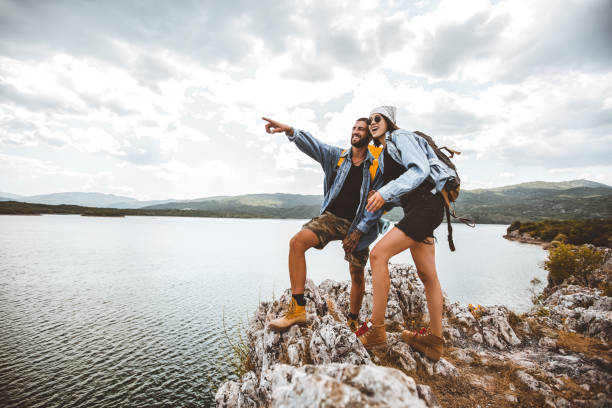 istock Hikers with backpacks sitting on cliff enjoying at the mountain lake 1321257079