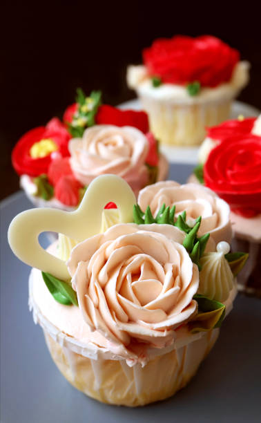 istock Closeup pastel pink rose shaped frosting cupcake with another in the backdrop 1321258262