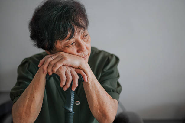 грустная азиатская китаянка старшая женщина у себя дома портрет - loneliness стоковые фото и изображения