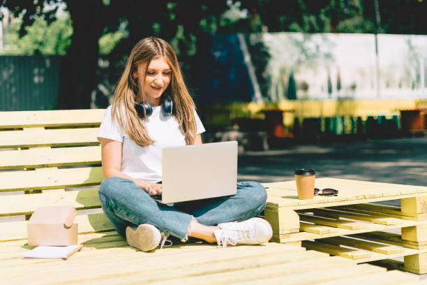 istock Woman using laptop sitting on the bench 1321259254