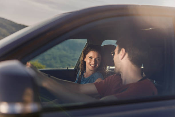 Happy couple talking while enjoying in their trip by car.