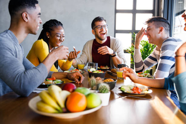 istock Young cheerful friends talking during lunch at home. 1321259676