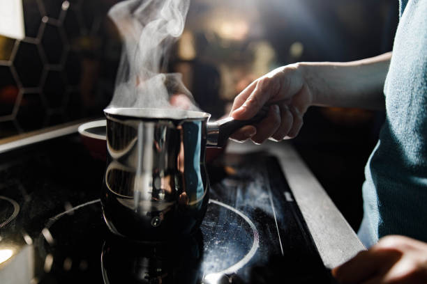 Close up of making coffee in cezve! Close up of unrecognizable woman making coffee in cezve during morning in the kitchen. turkish coffee pot cezve stock pictures, royalty-free photos & images