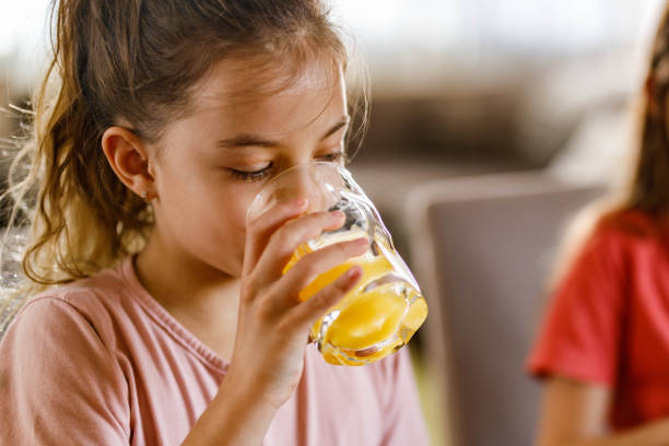 istock Little girl drinking fresh orange juice. 1321260721