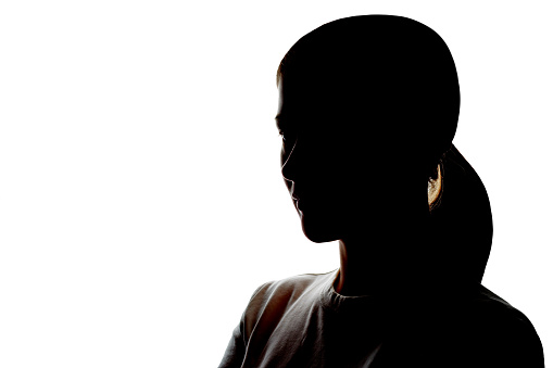 Dark silhouette of a young woman on a white background close-up.