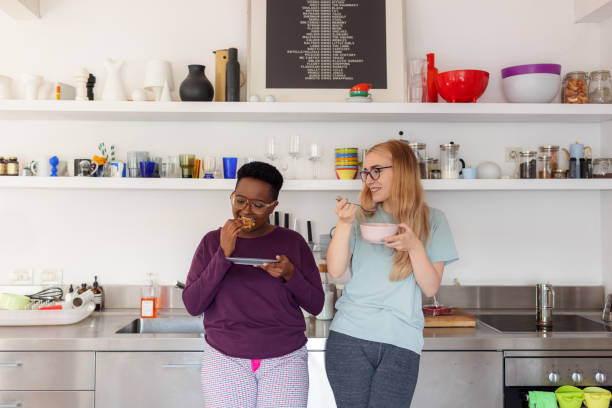 istock Two Female Friends Eating Breakfast In The Kitchen 1321263132