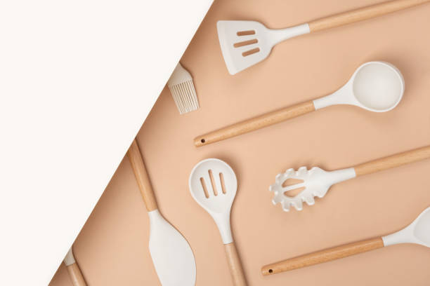 istock Cooking utensil set. Silicone kitchen tools with wooden handle on beige background with copy space. Top view Flat lay 1321264180