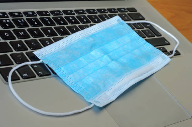 istock View on a medical mask on an open laptop pc. 1321266387