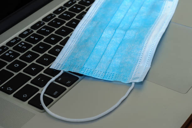 istock View on a medical mask on an open laptop pc. 1321266430
