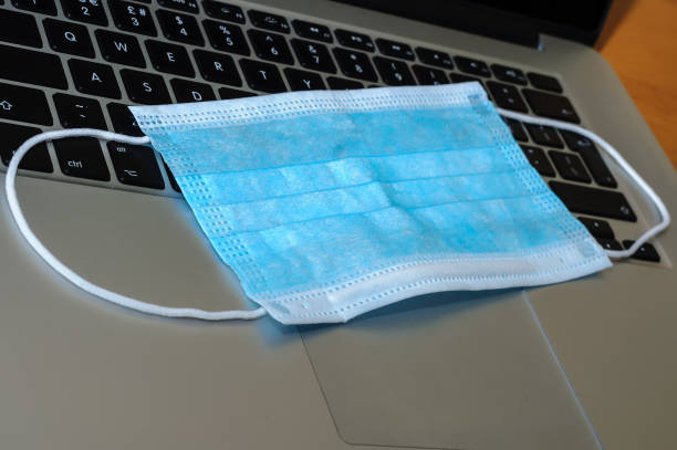 istock View on a medical mask on an open laptop pc. 1321266442