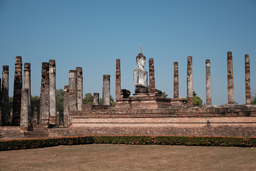 Ruins of ancient temples, only bricks and old Buddha statue in the Sukhothai Historical Park.