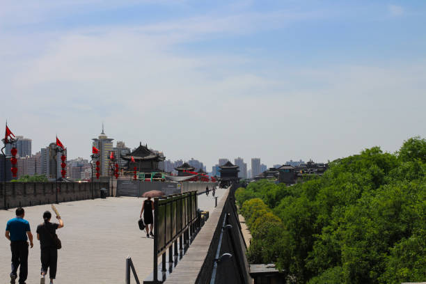 사람들이 걷고 있는 전통적인 붉은 중국 등불이 있는 xi'an 시의 넓은 오래된 도시 벽은 푸른 하늘을 배경으로 걸어다녔습니다. 시안. 중국. - china xian chinese lantern wall 뉴스 사진 이미지