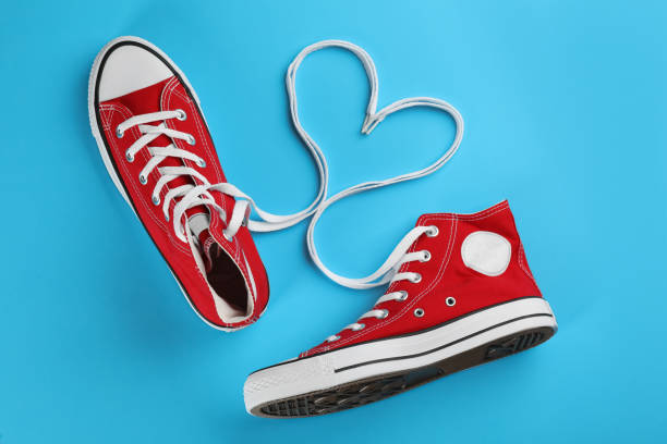 Balck Sneakers and heart shape from laces on red background. This file is cleaned and retouched.