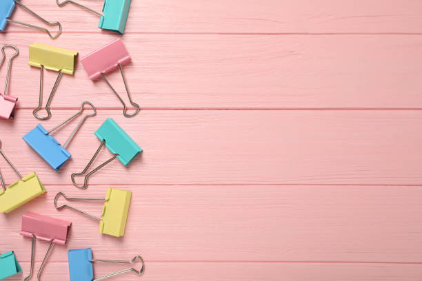 istock Colorful binder clips on pink wooden background, flat lay. Space for text 1321271588
