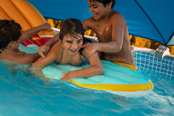 istock Three Happy Kids Having Fun in the Pool 1321272234