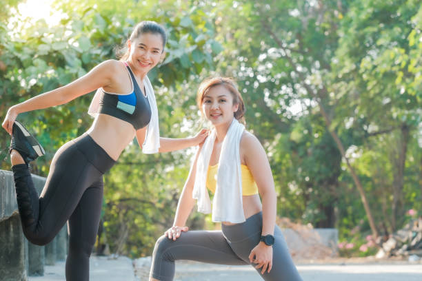 istock Asian women doing stretching exercises together before an evening jogging practice in the park. 1321272447