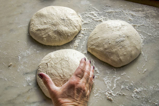 istock female hand taking a piece of pizza dough 1321277329