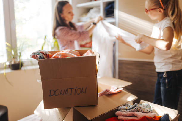 istock Mother and daughter sorting clothes for donation 1321278094