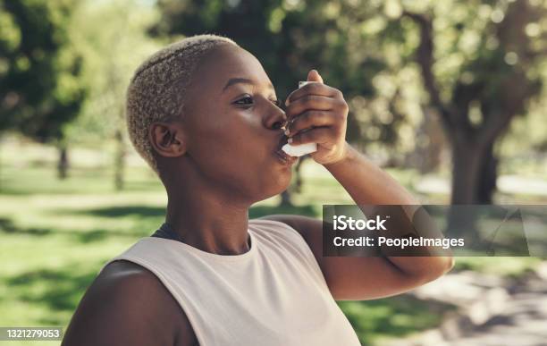 Shot Of A Young Woman Taking A Break During A Workout To Use Her Asthma Pump Stock Photo - Download Image Now