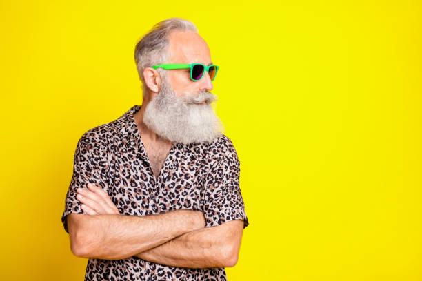 istock Portrait of attractive content grey-haired man folded arms looking aside copy space isolated over bright yellow color background 1321279217