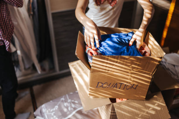 istock Mother and daughter sorting clothes for donation 1321284960
