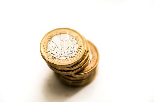 A stack of one pound coins against a white background.