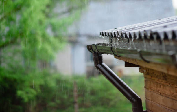 istock Rain water falling down from house roof in rainy season. 1321286658