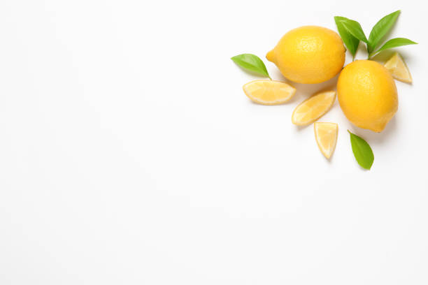 istock Whole and cut lemons with leaves on white background, top view 1321286961