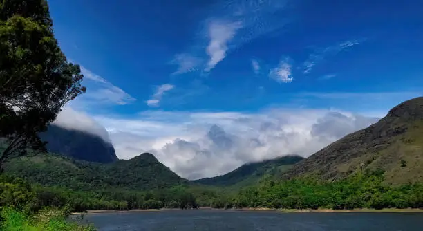 Scenic landscape with blue sky mountains & clouds from Kadamparai dam backwaters at Anamalai Tiger Reserve earlier known as Indira Gandhi Wildlife Sanctuary and National Park near Pollachi, Tamilnadu
