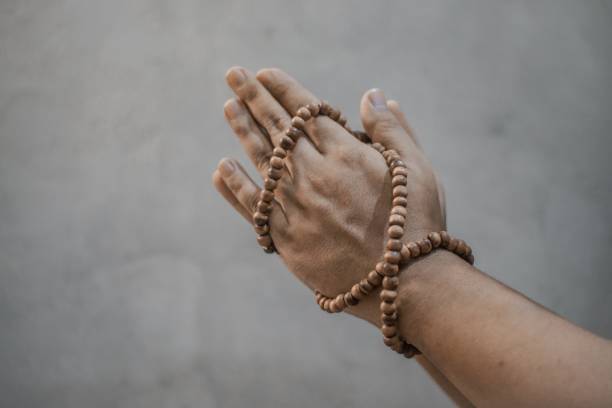 istock Hand wrapped in prayer beads 1321292566