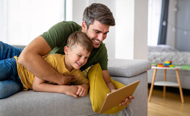 istock Happy father and son playing with digital tablet at home 1321293999