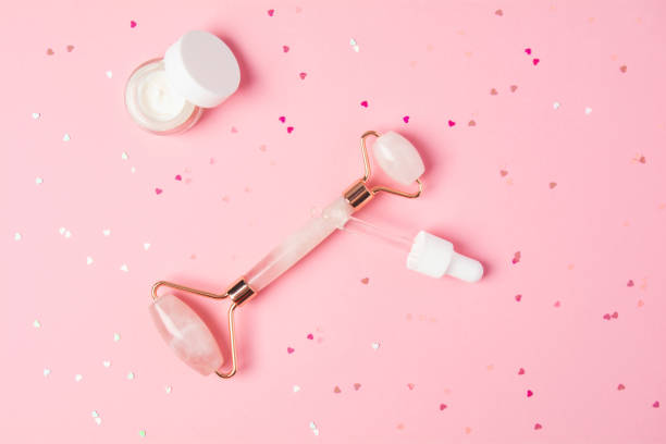 istock Massage quartz roller and dropper with cosmetic product on pink background 1321299986