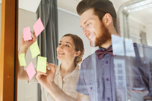 istock happy creative team writing on stickers at office 1321300684