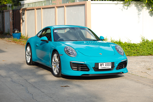 Cyan colored Porsche 911 parked in residential district of Bangkok Ladprao