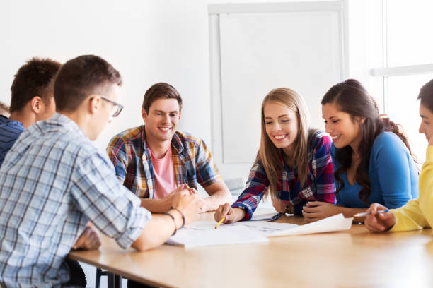 istock group of smiling students with blueprint 1321302688