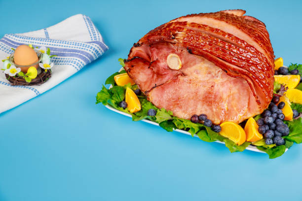 istock Spiral sliced and glazed ham on blue table. 1321306600