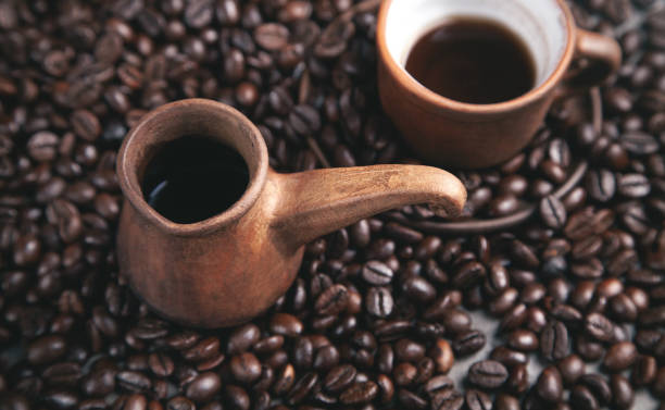 istock Clay coffee cup and pot on coffee beans. 1321306761