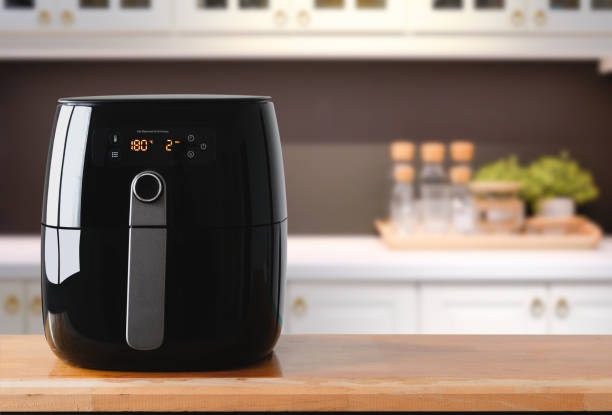 Air fryer machine cooking potato fried in kitchen.  Lifestyle of new normal cooking. stock photo