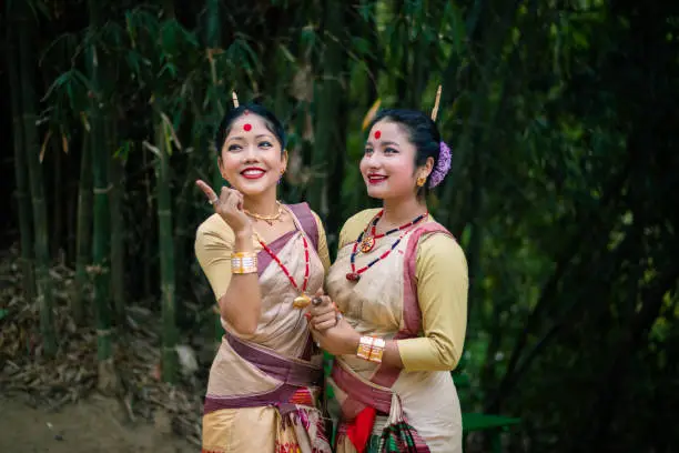 girls in dance move isolated dressed in traditional wearing on festival with blurred background image is taken on the occasion of bihu at assam india.