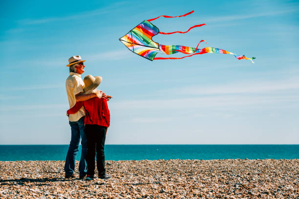 istock Senior couple flying colorful rainbow kite at beach 1321307923