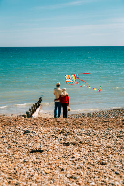istock Senior couple flying colorful rainbow kite at beach 1321307961