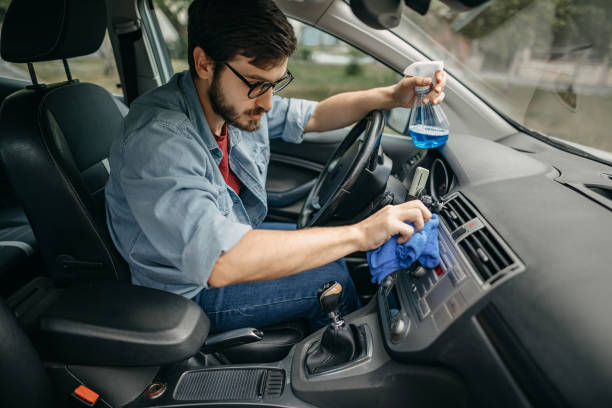 istock Young man cleaning car interior with wipe 1321308020